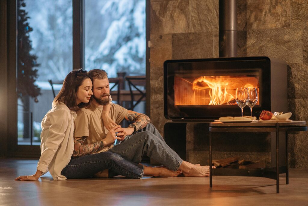 pexels-photo-6667204-6667204 A couple enjoying warmth by the fireplace in a cozy room during winter.